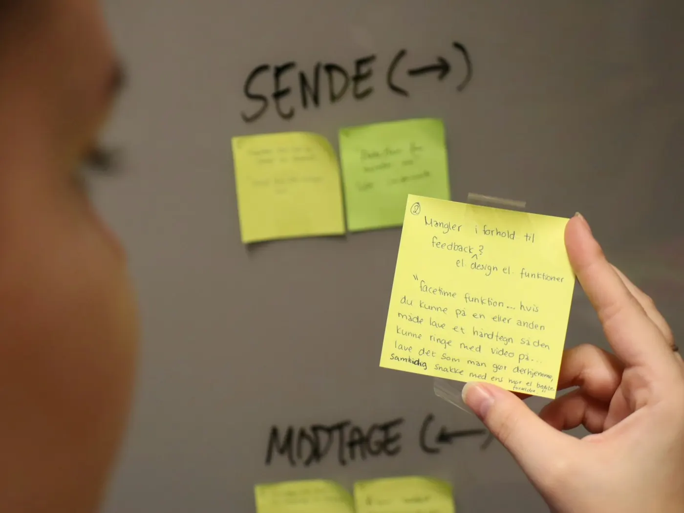 Alguien ordenando ideas en una pizarra llena de notas